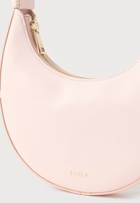Τσάντα ώμου σε ανοιχτό ροζ δέρμα σε σχήμα ημισέληνου με χρυστό φερμουάρ και μικρό χρυσό λογότυπο "Furla" στο μπροστινό μέρος.