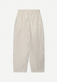 Široké pruhované kalhoty v krémové barvě s hnědými svislými pruhy. Mají elastický pas a jednu našitou kapsu na pravé straně.