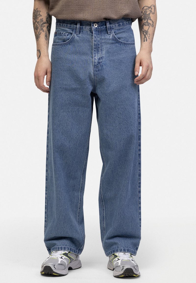 Jeans din denim albastru cu talie înaltă și croială lejeră, cu un finisaj texturat. Au cinci buzunare, fermoar și cusături contrastante pe umeri.