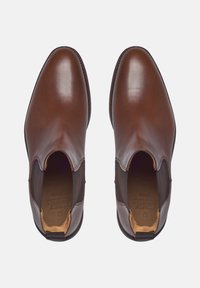 Bruine leren Chelsea-boots met elastische zijpanelen en een ronde neus. Glad oppervlak met een contrasterende bruine hak en stikseldetails.