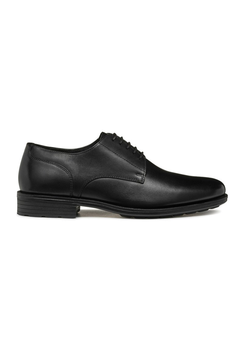 Scarpa da uomo in pelle nera con punta arrotondata, texture liscia e dettagli con lacci. Presenta un tacco basso impilato e sottili accenti di cucitura.