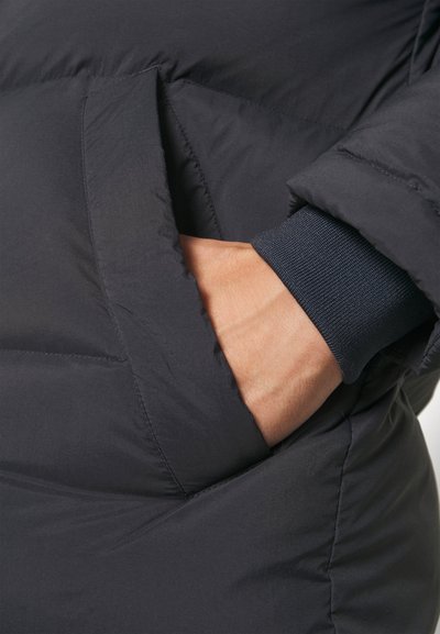 Navy puffer jacket fabric with a subtle sheen; features a side pocket and ribbed knit cuff at the wrist for snug fit.