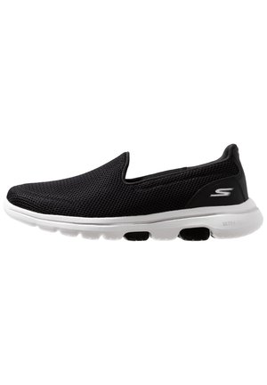 Sort slip-on sneaker med åndbar mesh-overdel og hvid polstret sål med sorte luftpuder, side-logo nær hælen.