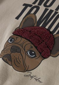 Illustration d'un bulldog marron portant un bonnet en tricot bordeaux texturé avec le texte "Détends-toi" en dessous.