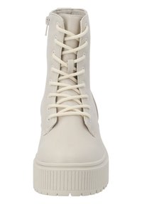 Botas de tobillo de encaje crema, confeccionadas en cuero suave, con punta redondeada, suela gruesa estriada y cremallera lateral para facilitar su uso.