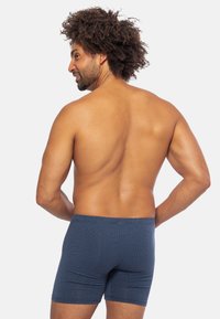Pantaloni boxer a quadri blu realizzati in tessuto morbido, con un design aderente e una vita elastica.