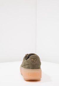 Sneaker in suede verde oliva con suola in gomma traslucida pesca, design con lacci piatti e logo in oro embossato sul tallone.