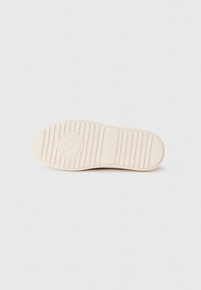 Weiße Gummisohle mit Rillen, kreisförmigem Michael Kors-Logo und strukturiertem Muster. Glatte Oberfläche mit einem leicht erhöhten Fersenbereich.
