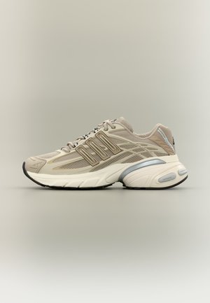 Baskets de sport beiges avec panneaux en mesh, superpositions en plastique, semelle épaisse rembourrée et semelle extérieure en caoutchouc noir, vues de côté sur fond neutre.