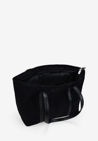 Bolso tote de ante negro con asas de cuero, cierre de cremallera y un interior espacioso. Sin patrones visibles, textura lisa, diseño minimalista.