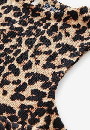 Úplet s leopardím potiskem a strukturovaným povrchem, s černými a béžovými vzory. Výstřih je kulatý s vyříznutými detaily.