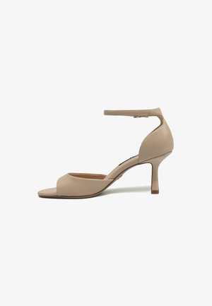 Sandale beige pour femme à bout ouvert avec bride à la cheville et talon fin de hauteur moyenne, vue de profil sur fond blanc.