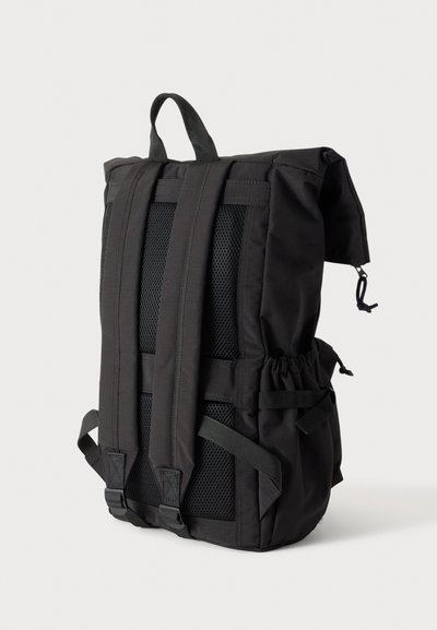 Sac à dos noir avec bretelles rembourrées, panneau arrière en mesh, poches latérales et poignée supérieure, montré de dos sur un fond uni.