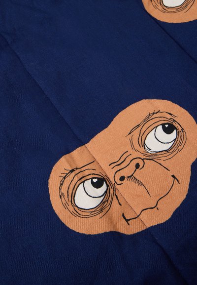 Mėlyna audinio medžiaga su atspausdinta animacinio personažo veido iliustracija, kuriame didelės akys ir išryškėjęs nosis. Tekstūra atrodo lygi.