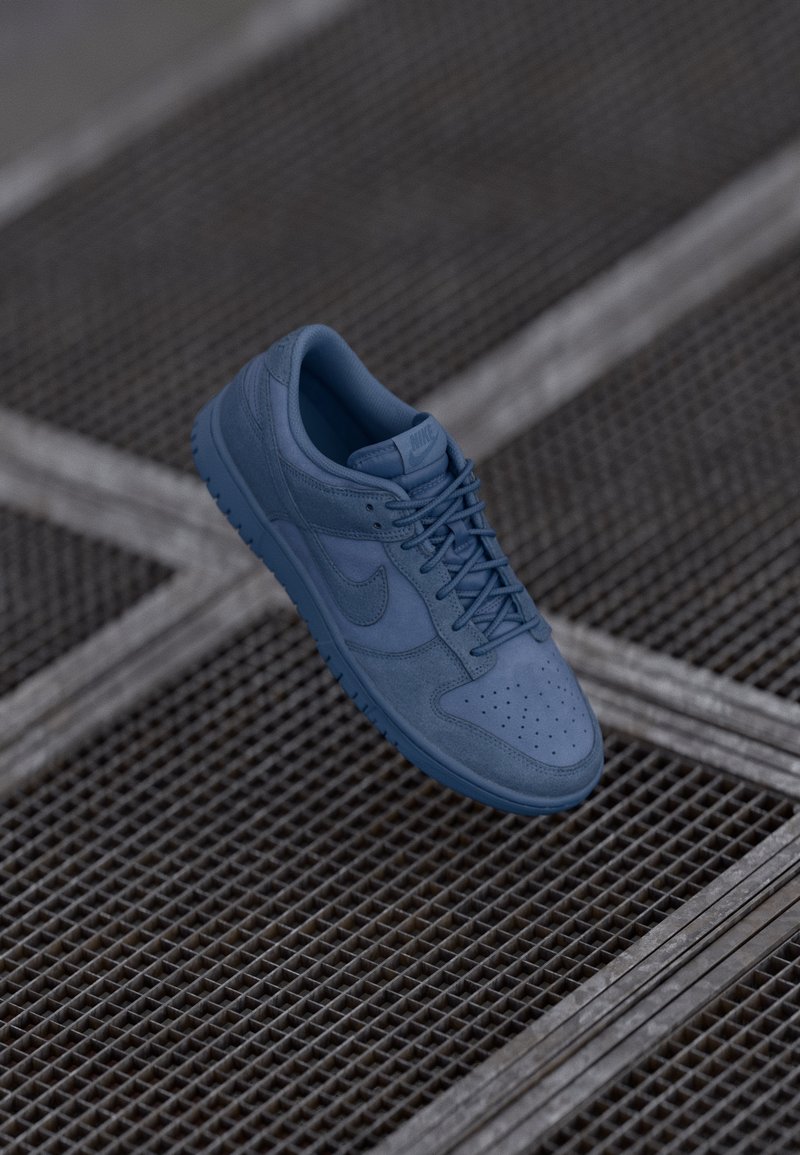 Sinine nahkne tennis, millel on sile viimistlus, aukudega varvasetootja ja kokku sobivad paelad. Omab tikkitud Nike logo ja tekstureeritud kummitalda.