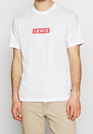 T-shirt bianca in cotone con logo "LEVI'S" rosso rettangolare sul petto. Vestibilità classica con maniche corte e scollo rotondo.