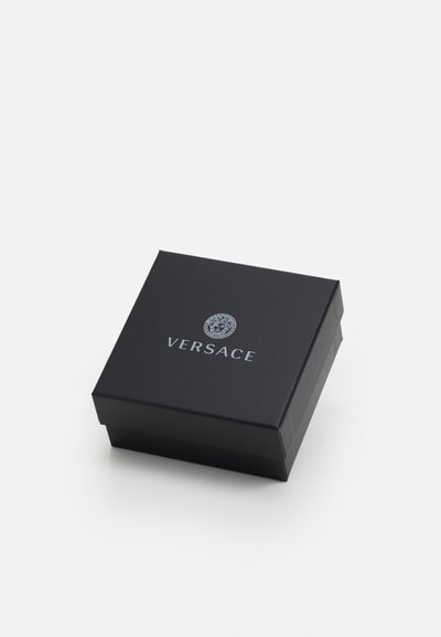 Must tasane musta kast, millel on sile tekstuur ja mille ülemisel pinnal on hõbedane "Versace" logo ja embleem.