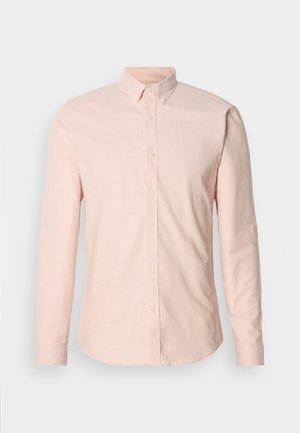 Hele-roosa pikkade varrukatega särk, millel on nööbitav krae, esiklapiga ja tavapärased mansetid. Valmistatud siledast, kootud kangast.