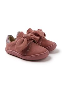 Chaussures en suède rose avec un grand nœud à l'avant, dotées d'une semelle douce et de paillettes texturées à l'arrière.