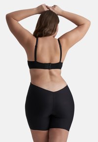 Zwarte verstelbare beha met drievoudige haaksluiting aan de achterkant en bijpassende hoge naadloze shorts. Gladde stof en eenvoudig ontwerp zonder patroon.