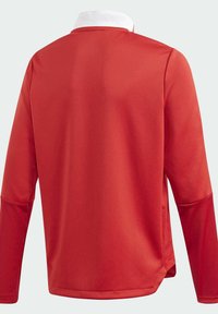 Camisa roja de manga larga con un cuello blanco, que presenta una textura suave y un corte relajado. La parte trasera muestra un diseño sencillo sin logotipos ni patrones.