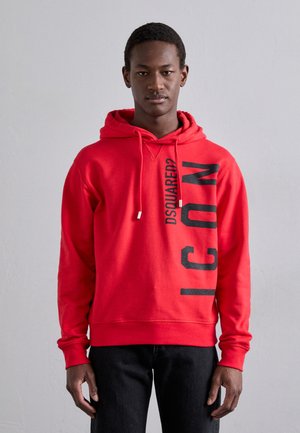 Red hooded sweatshirt made of soft fabric, featuring a large black "ICON" print and "DSQUARED2" logo on the front, with a relaxed fit.