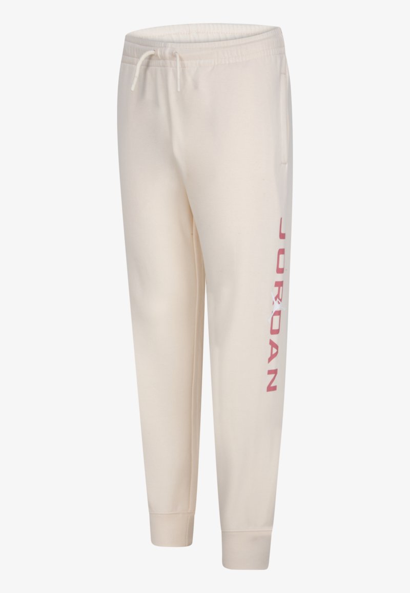Cremfarbene Jogginghosen aus weichem Stoff, mit schmaler Passform, elastischem Bund und "JORDAN" in Pink entlang des linken Beins bedruckt.