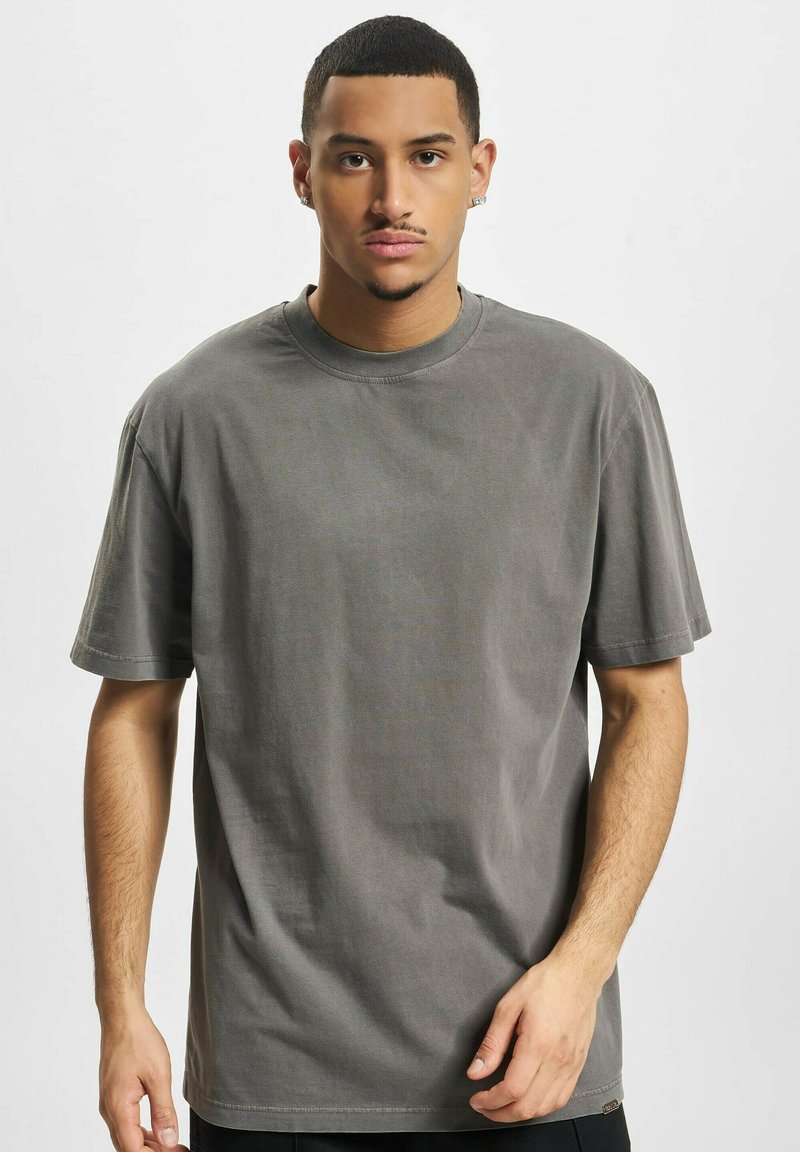 Grå bomull crew neck t-skjorte med korte ermer, avslappet passform og subtil tekstur; har en liten logomerketag på kanten.