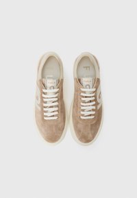 Lys brun semsket sneakers med hvite snøring, en beige såle og subtile logo detaljer. Glatt tekstur med sydd detaljer.