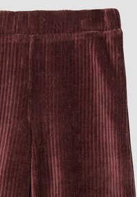 Burgundowe spodnie z grubej struktury w prążki, z elastycznym paskiem w talii i lekko otwartym dołem, zapewniające wygodne dopasowanie.