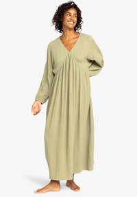 Lange, lichte, olijfgroene jurk met een V-hals, geraffineerd ontwerp en lange, luchtige mouwen. Getextureerde stof met een ontspannen silhouet.