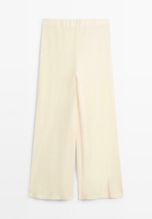 Buks i cremefarvet, vidtbenet design med elastisk taljebånd, vist fladt mod en hvid baggrund.