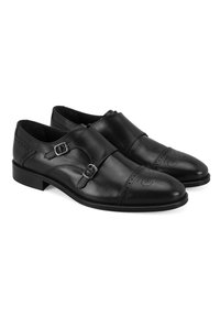 Schwarze Leder-Doppel-Monk-Schnürschuhe mit durchbrochener Brogue-Verzierung und glatter Oberfläche. Abgerundete Zehenpartie, flache Sohle und silberne Hardware-Akzente.