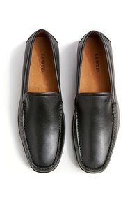 Zwarte leren loafers met gestikte details, een afgeronde vorm en een gladde textuur. Tankleurige binnenzolen met merkopdruk "LLOYD GERMANY."
