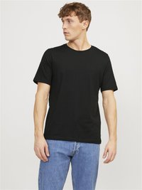 T-shirt en coton noir avec un col rond, des manches courtes et une coupe droite, associé à un jean en denim bleu clair.