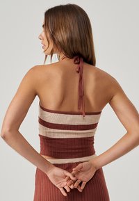 Top halter a righe marroni e beige, con un design aderente e chiusura posteriore con lacci per una vestibilità regolabile.