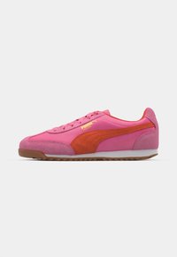 Sko med en pink overdel i ruskind og stof, suppleret af en orange accentstribe og hvid sål. Har snørelukning.