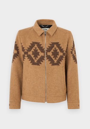 Brown wool jacket with dark geometric patterns across chest and sleeves, front zipper, and buttoned cuffs.