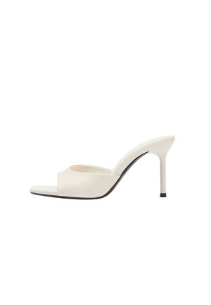 Mule à talon haut couleur crème avec bout ouvert, talon aiguille fin et dessus en cuir lisse, vue de côté sur fond blanc.