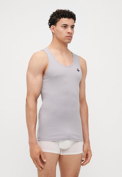 Débardeur gris à côtes avec un col rond et un accent de logo noir, porté avec des dessous blancs. Le tissu semble lisse et élastique.
