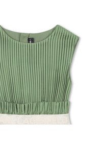 Πλισέ πράσινο τοπ με στρογγυλή λαιμόκοψη· διαθέτει υφή υφάσματος και αντίθετη μέση με κεντημένο το "KARL LAGERFELD" σε ανοιχτό χρώμα.