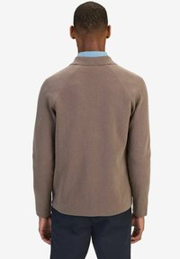 Bruine geribbelde cardigan met een gestructeerde kraag en lange mouwen, voorzien van een textiel met textuur en een neutraal kleurenpalet.