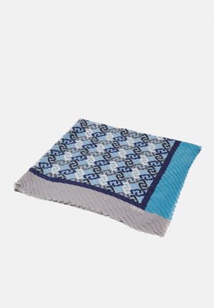 Écharpe pliée avec un motif géométrique imbriqué en noir, blanc, gris et bleu, bordures bleu clair et gris, avec un texte de marque subtil.