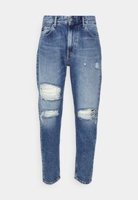 Lys blå denimjeans med avslappet passform, med slitte kneputer og mid-rise liv. Klassisk fem-lomme design.