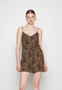 Rompér à motif léopard avec un décolleté en V, des bretelles spaghetti ajustables, une taille élastique avec un nœud et des shorts. Le tissu a une texture douce.
