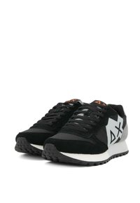Zapatillas negras y grises con parte superior de ante, detalle de logo blanco en contraste y suela de goma texturizada con cuello acolchado.