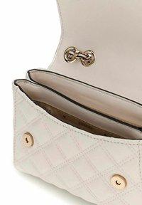 Sac à main en cuir beige matelassé avec une quincaillerie circulaire dorée. Deux compartiments à l'intérieur, présentant un intérieur lisse et une finition noire.