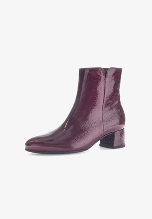 Bottine bordeaux en cuir verni avec un bout pointu, un dos fendu et un talon carré épais pour plus de stabilité.