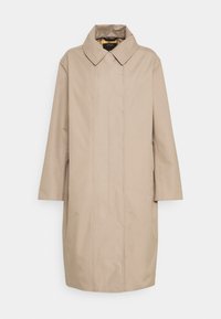 Trench coat largo beige con un amplio cuello, mangas largas y botones frontales ocultos, expuesto sobre un fondo blanco.