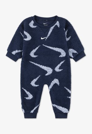 Tuta in pile blu navy con motivi bianchi a forma di swoosh Nike, polsini a coste e scollatura a V. Tessuto morbido e vestibilità comoda per il massimo comfort.